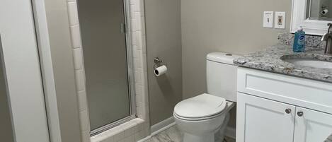A bathroom with a shower, toilet, and sink.