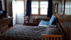 A bedroom with a bed, a chair, a desk, and a window with curtains. - Dennisport - Studio Condo w kitchenette  - Walk to beach  (Dennis)