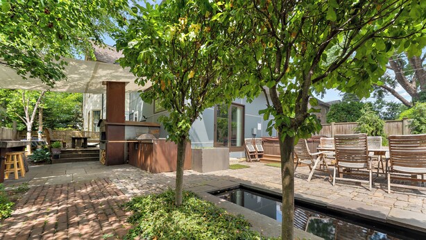A patio area with a brick floor, outdoor seating, a pool, and a covered barbecue area. - Victorian With An Amazing Location, Incredible Yard With Private outdoor Hot tub (Minneapolis)