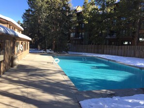 Une piscine dotée d’une terrasse en bois et d’une clôture en bois.