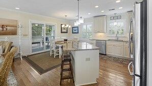 A spacious kitchen with a large island, white cabinetry, and a stainless steel refrigerator. - Private Pool, 2 Blocks to Beach--Perfect Family Getaway! (Isle of Palms)