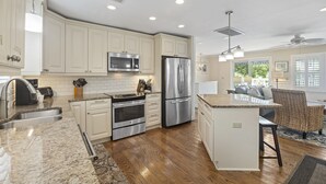 A modern kitchen with white cabinets, stainless steel appliances, and a central island. - Private Pool, 2 Blocks to Beach--Perfect Family Getaway! (Isle of Palms)