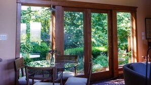 Une pièce spacieuse avec de grandes fenêtres, un coin repas avec des chaises et une table.