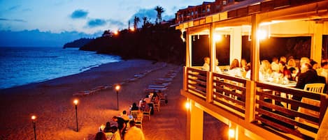 Un restaurant situé en bord de mer, avec une terrasse offrant une vue sur l’océan.