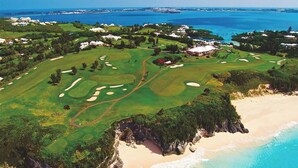 Vista aérea de un campo de golf con una playa y el océano.