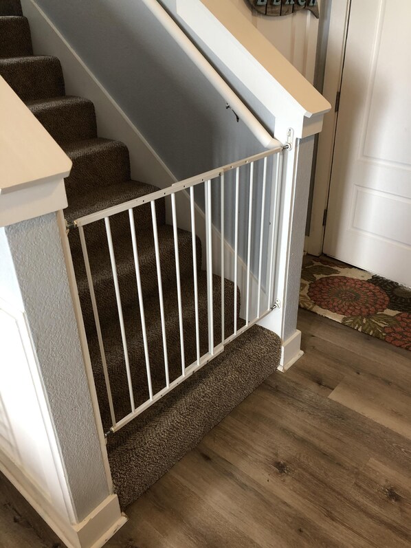 A staircase with a white railing and carpeted steps.