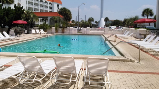 A swimming pool with lounge chairs and a tall water feature. - Paradise found -  close to everything and endless beautiful beach access (FT Walton beach)