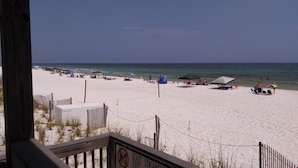 A beach with a wooden fence, beach umbrellas, and a no glass fires containers sign. - Paradise found -  close to everything and endless beautiful beach access (FT Walton beach)