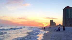 A beach with waves, a sunset, and buildings in the background. - 7th Fl. Ocean Front Balcony💎So Clean, WIFI, Pools, Athletic Courts, Grills.. (Orange Beach)