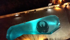 A large, illuminated, oval-shaped object with a circular design, suspended in an indoor space with a staircase and a railing visible below. - 7th Fl. Ocean Front Balcony💎So Clean, WIFI, Pools, Athletic Courts, Grills.. (Orange Beach)