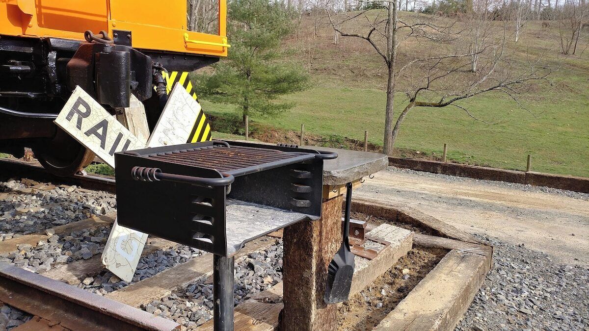 A railway crossing with a metal barrier and a 'RAIL' sign.