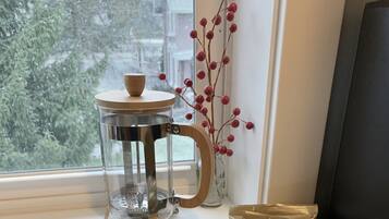 A kitchen counter with a tray holding breakfast items, a coffee maker, and a decorative vase.
