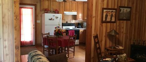 A cozy wooden interior with a dining area, kitchen, and living space.