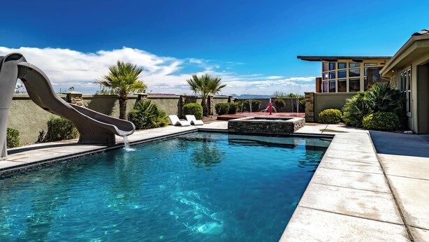 A swimming pool with a slide, surrounded by a patio with lounge chairs and palm trees. - 5 Bedrooms with Heated Private Pool, Last minute rates are posted! (Saint George/Washington)