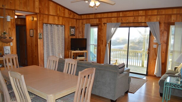 A wooden interior with a dining table, chairs, a sofa, and a television. - Beach? We gotcha Beach-oceanside, only steps from uncrowded beautiful beach  (Nags Head)