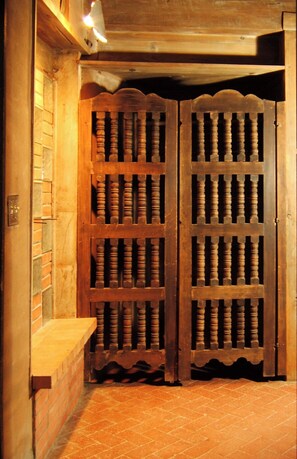 Traditional door with a brick wall and wooden ledge, set against a patterned tile floor.