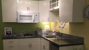 A kitchen with white cabinets, a microwave, a coffee maker, and a clock on the wall. - the Beach Suite on Lemolo!    CLEAN & PRIVATE ... getaway & relax. (Poulsbo)