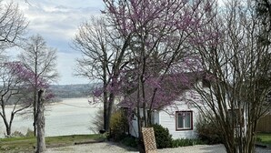 A house with a gravel driveway, a bird bath, and a view of a lake. - Clean, Family/Pet Friendly Lake View, 2-Bdrm Cabin Near Several Marinas/launches (Gamaliel)