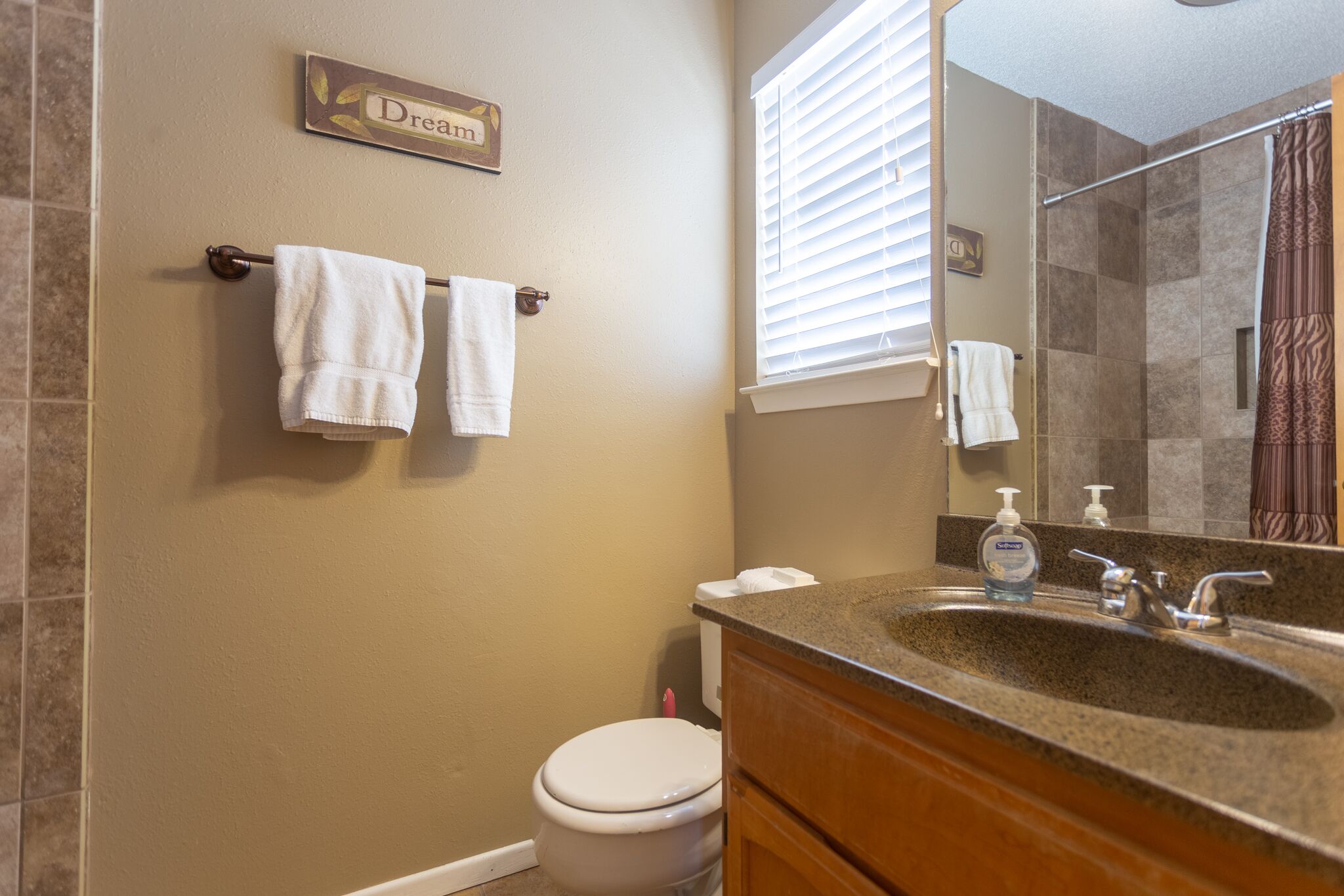 A bathroom with a toilet, sink, and towel rack.