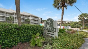 A sign for Mistral with a view of a multi-story building and lush greenery. - GULF FRONT - GREAT VIEWS - Direct Walk Out - Only Steps to Private Beach (Inlet Beach)