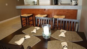 A dining area with a table set for four, including placemats and napkins. - GULF FRONT - GREAT VIEWS - Direct Walk Out - Only Steps to Private Beach (Inlet Beach)