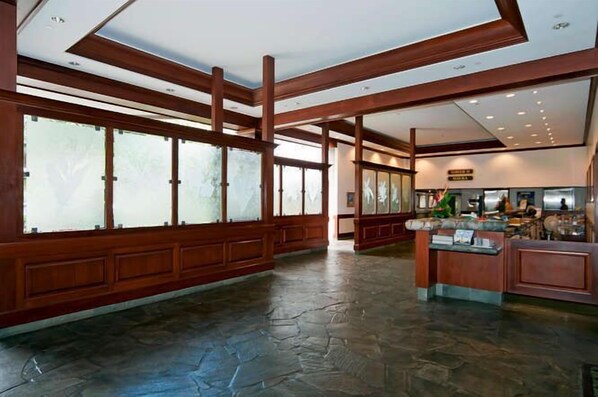A spacious lobby with wooden beams, large windows, and a reception desk. - DESIRABLE WAIKIKI BANYAN OCEANVIEW CORNER UNIT - FREE SECURED PARKING, WIFI (Honolulu)
