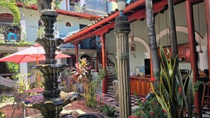 A courtyard with a fountain, outdoor seating, and a staircase leading to a balcony. - Casa Don Carlos a Gorgeous Colonial House! (Granada)