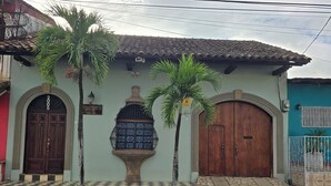 A building with a checkered entrance, a large wooden door, and a decorative blue window. - Casa Don Carlos a Gorgeous Colonial House! (Granada)