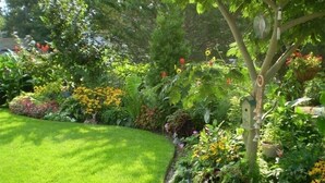 Un jardin bien entretenu, agrémenté de diverses plantes à fleurs et d’une pelouse parfaitement taillée.