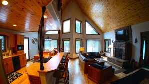 A spacious living area with a kitchen, dining area, and fireplace. - Exceptional Chalet near Harbor, Nubs Nob and Boyne Highlands Ski and Golf Resort (Harbor Springs)