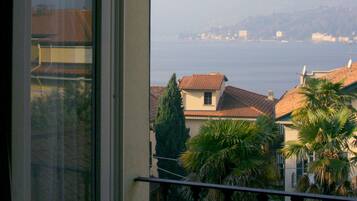 Un balcone con vista su un lago e edifici in lontananza.