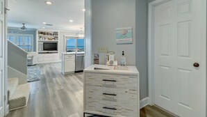 A modern kitchen with white cabinetry, a built-in oven, and a large island with drawers.