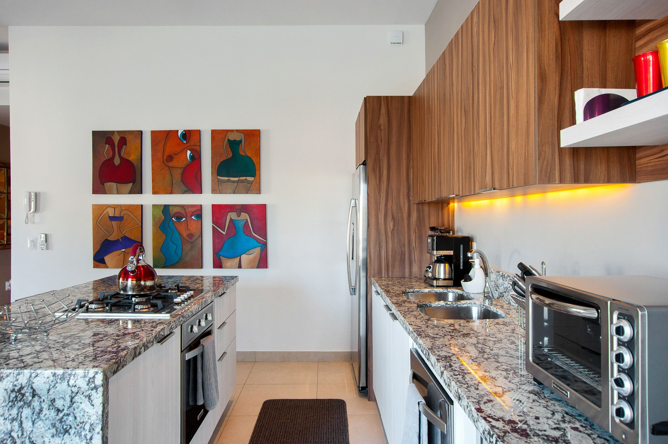 A modern kitchen with granite countertops, stainless steel appliances, and wooden cabinets.