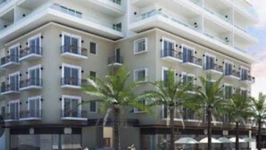 A multi-story hotel with balconies, palm trees, and a clear sky. - BRAND NEW, LUX ONE BEDROOM IN OLD TOWN, 3 BLOCKS FROM THE OCEAN, OLD TOWN (Puerto Vallarta)