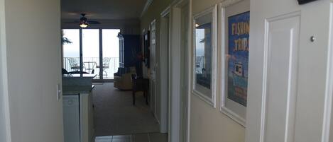 A hallway leading to a balcony with a view, a door labeled 2109, and a poster advertising fishing trips.