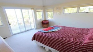Un dormitorio con una cama grande, una silla y una ventana.
