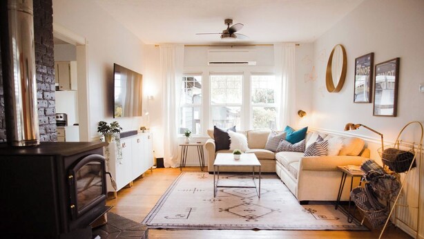 A cozy living room with a fireplace, a sofa, a coffee table, and a TV.