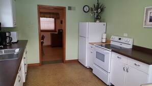 A compact kitchen with a refrigerator, stove, and sink.