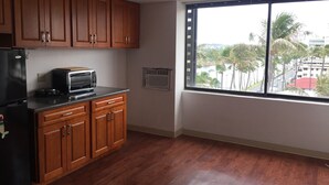 Una cocina con armarios de madera, un refrigerador negro y una tostadora en la encimera.