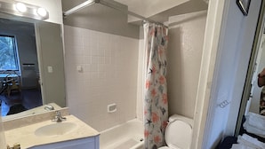 Un baño con lavamanos, tocador, bañera y retrete.