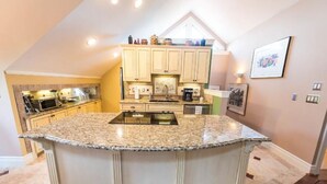 A kitchen with a central island, built-in cabinets, and a dining area.