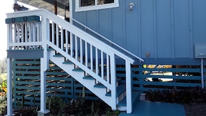 A blue house with a white staircase leading to a porch.