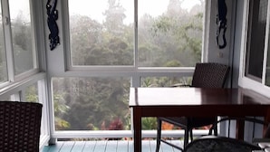 A room with a large window, a table, and two chairs.