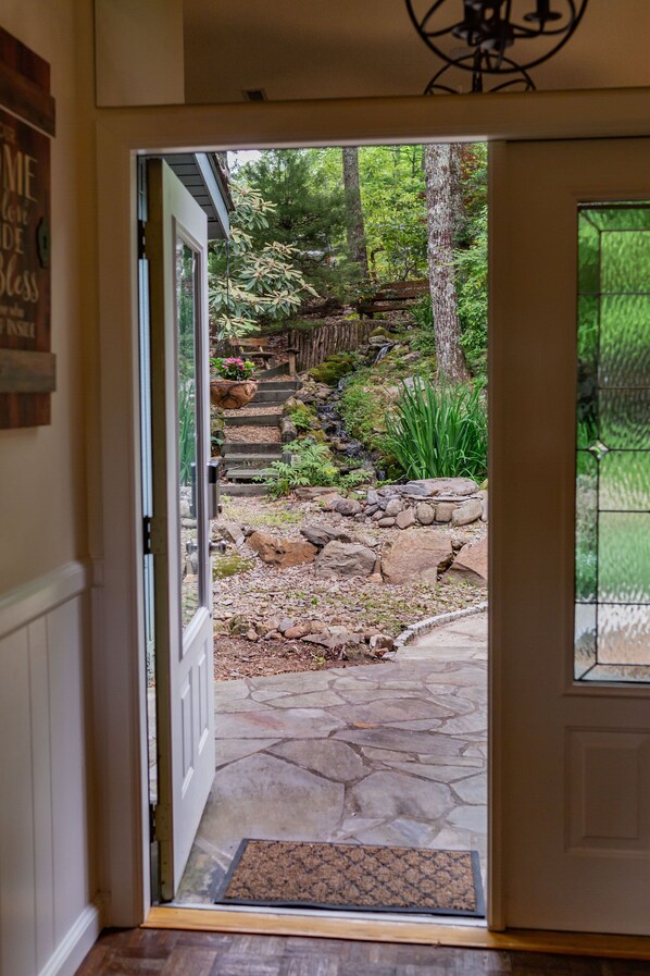 A stone pathway leading to a wooden deck with a metal gate.