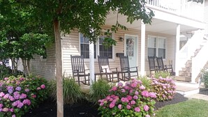 A house with a porch, outdoor seating, and hydrangea bushes. - Beach block! 4 Bed 2 Bath - 1st floor duplex! (Brigantine)