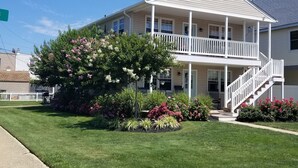 A two-story house with a covered porch and a staircase leading to the upper floor. - Beach block! 4 Bed 2 Bath - 1st floor duplex! (Brigantine)