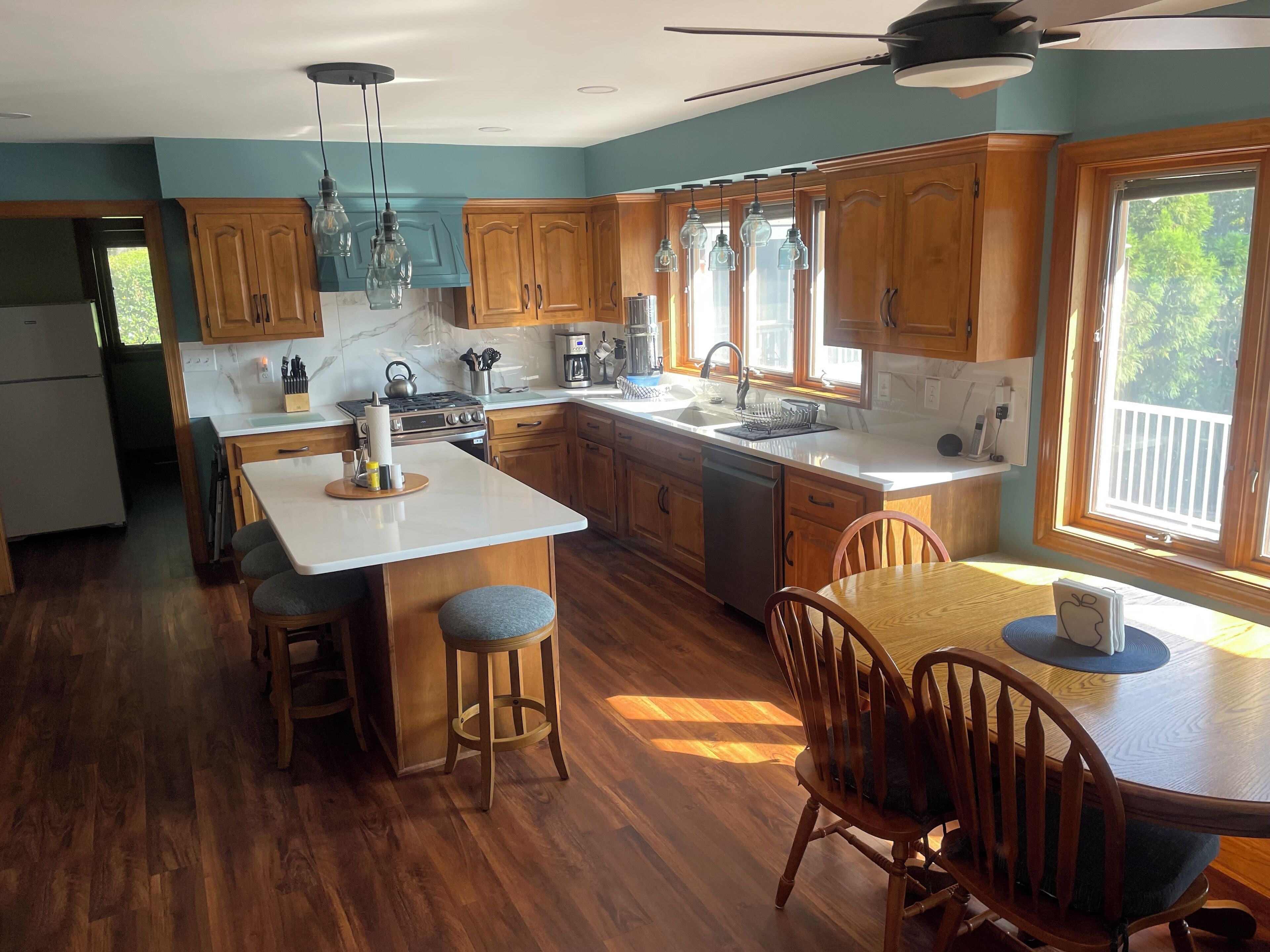 A spacious kitchen with wooden cabinets, a large island, and a dining area with a table and chairs.