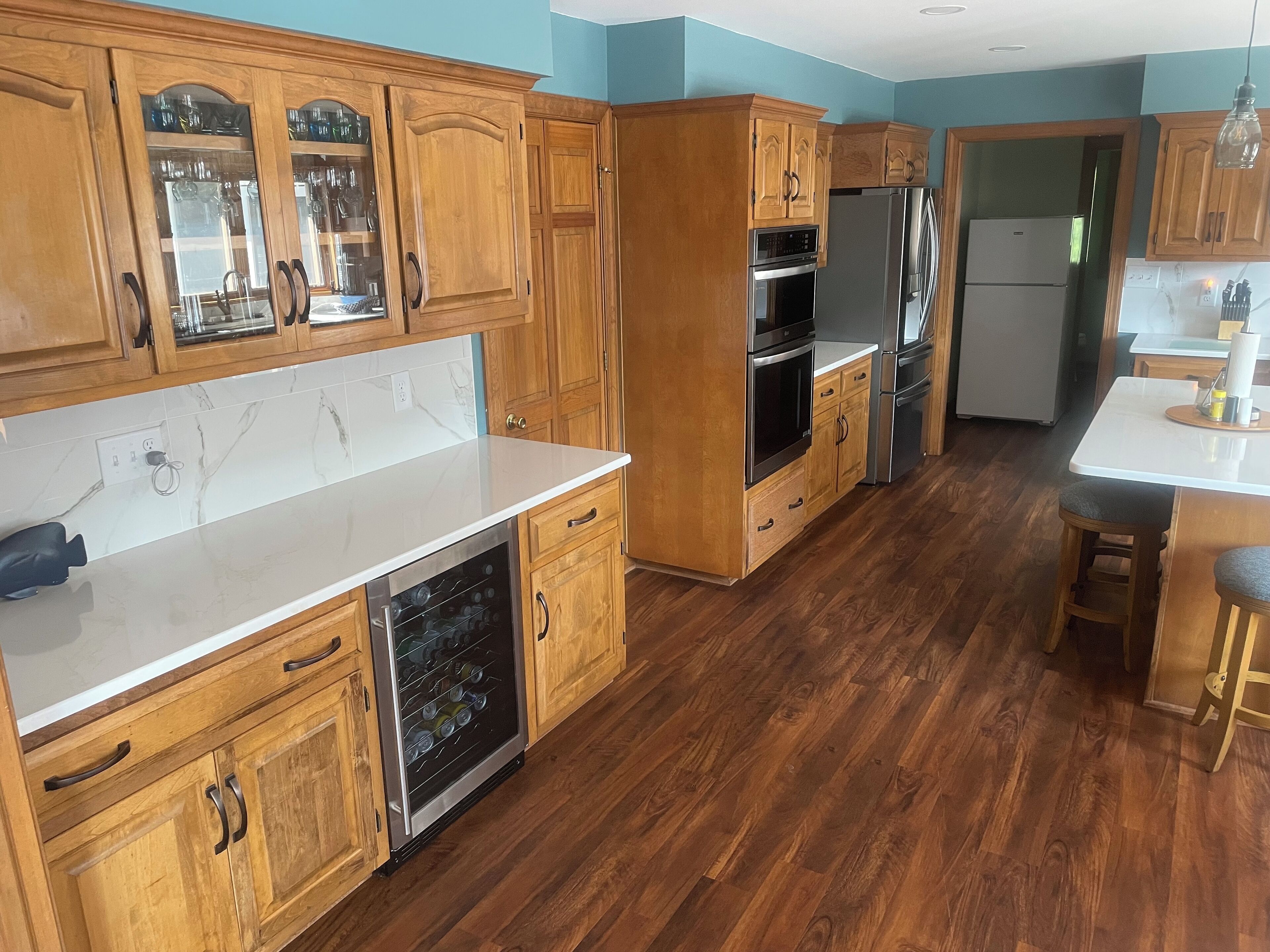 A kitchen with wooden cabinets, a dishwasher, stainless steel appliances, and a bar area.