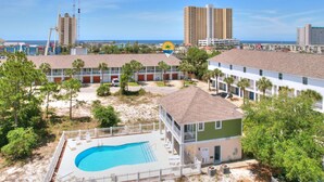Um resort com piscina, edifícios de vários andares e vista para a praia e o oceano.