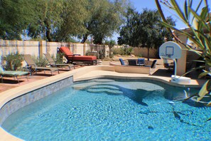 A swimming pool with a basketball hoop, lounge chairs, and a small fountain. - Gorgeous Glendale Home Sleeps 10 Pool, Hot Tub, (Glendale)